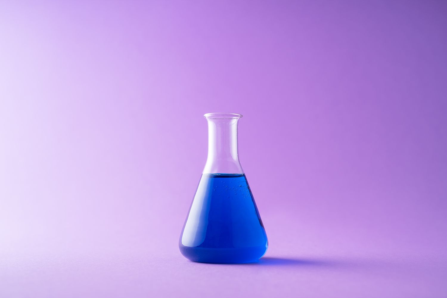 Aurora Analytics Home, Products: Background image of a flask containing a blue solution